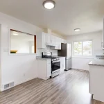 kitchen remodel with white cabinets and light wood flooring